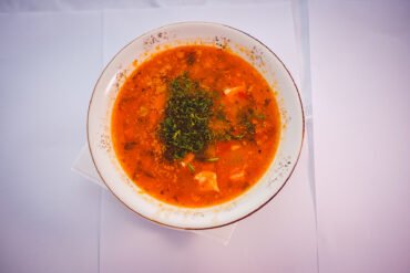 Supă tradițională românească în farfurie albă.